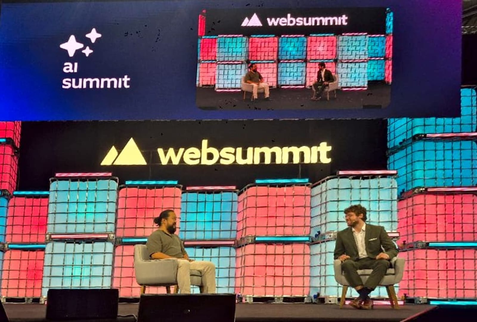 Foto tirada do palco com os palestrantes David Shim e Harry Booth durante a palestra no Web Summit Rio 2026
